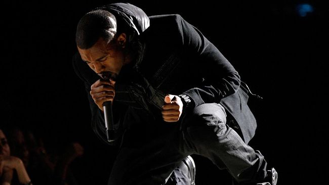 Hampir seluruh wajah Kanye West tertutup ketika menghadiri acara peragaan busana bersama Julia Fox di Paris.