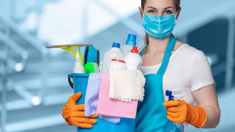Cleaning lady with tool in cleaning in mask on a blurred background.
