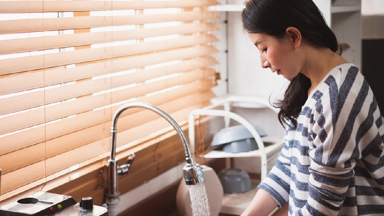 Asian maid housewife washing cleaning dishes in kitchen