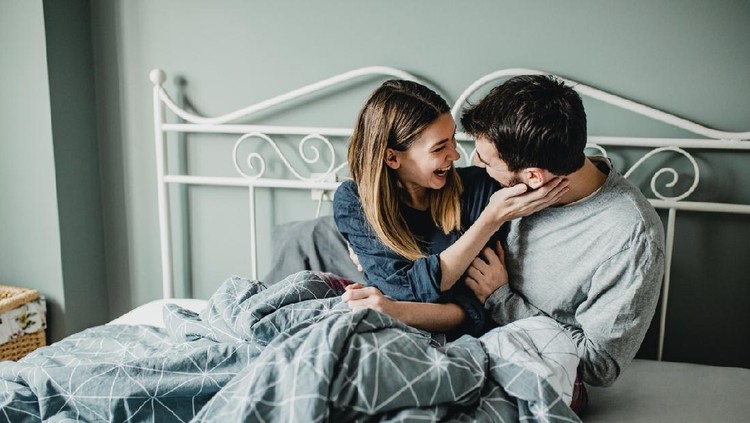 Young couple is hugging in bed in the morning