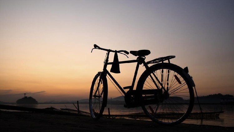 A bicycle in the banks of Brahmaputra river at sunset
