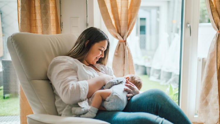happy family mother playing and hug with newborn baby  in bed