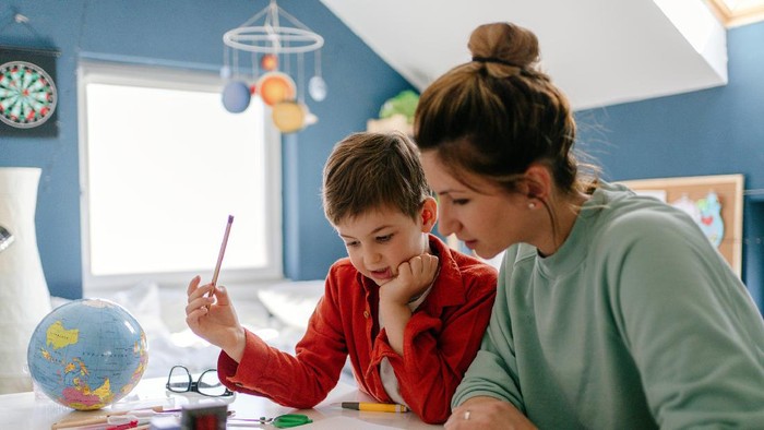 Asian boy attending online classroom at home.