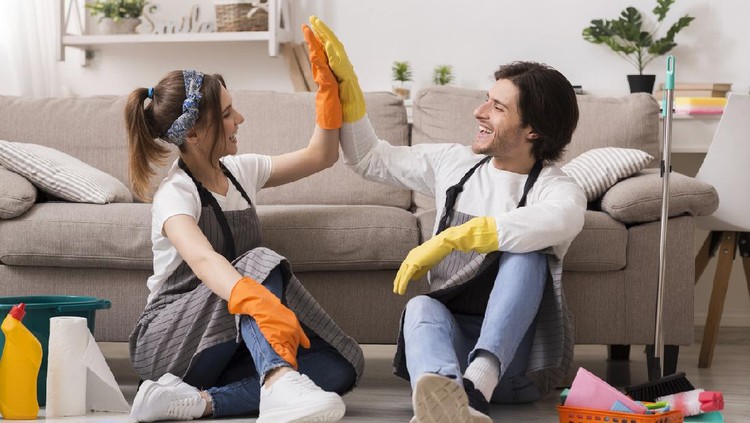 Housekeeping And Cleaning Service Concept. Happy Couple Giving High Five To Each Other After Spring-Clean In Apartment