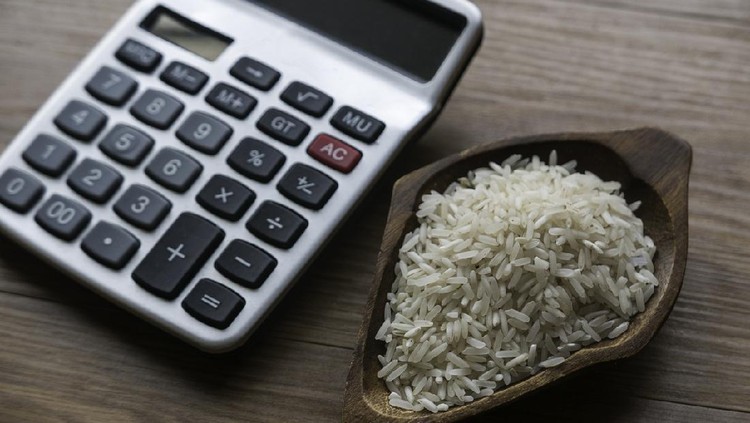 Selective focus of rice and calculator on wooden background.