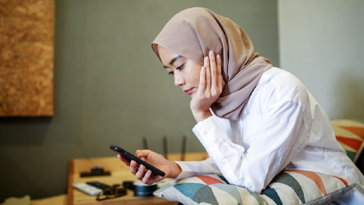 One women looking at the phone during eid celebration in Malaysia
