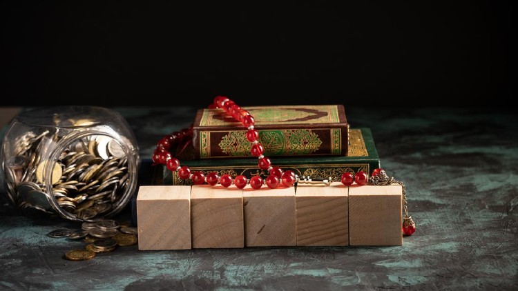 Islamic concept: The holy Quran and Tasbih (rosary beads) on dark background