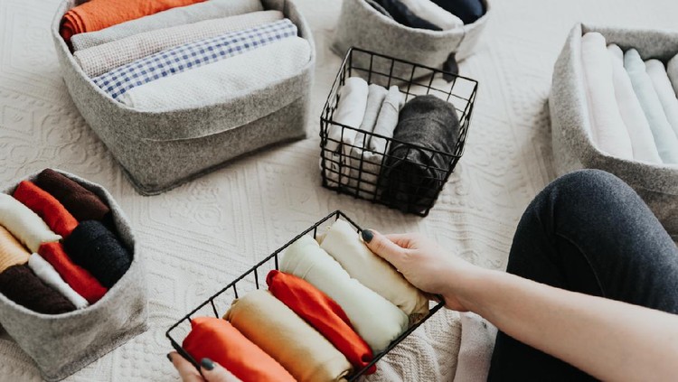 Wardrobe storage system. Clean up clothes with konmari method (Marie Kondo). Clothes neatly folded in bedroom