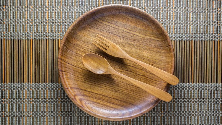 Dinning utensil set up on a green weaved bamboo mat