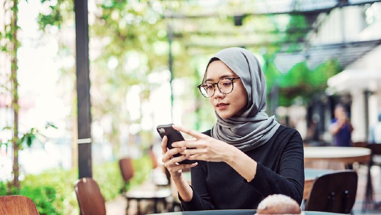 Indonesian or Malaysian woman with headscarf in the restaurant