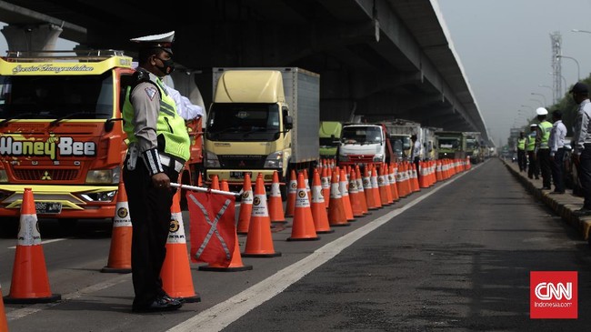 Polisi mengecek truk di perbatasan Jakarta guna mengantisipasi mobilisasi massa mengikuti demo buruh dan mahasiswa di depan gedung DPR.