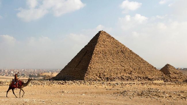 Ada pemandangan tak terduga di puncak Piramida Giza, Mesir. Seekor anjing tampak menikmati pemandangan di sekitar puncak salah satu keajaiban dunia tersebut.
