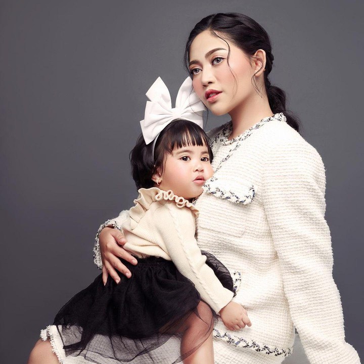 <p>Pada satu kesempatan, Chava yang mengenakan pita putih besar tampak menyender ke dada sang Bunda, nih. Keduanya kompak mengenakan pakaian putih hitam.  (Foto: Instagram: @rachelvennya)</p>