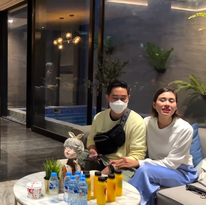 <p>Ruang tamu tersebut juga dilengkapi dengan meja bar dari kayu nan hangat. Kombinasi dapur minimalis yang dihiasi <em>vertical garden</em> itu membuat rumahnya tampak seperti villa untuk berlibur. (Foto: YouTube NisNaz Channel)</p>