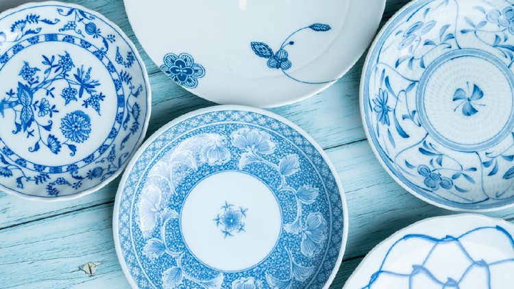 a ceramic dish with blue patterns on a rustic blue wood background