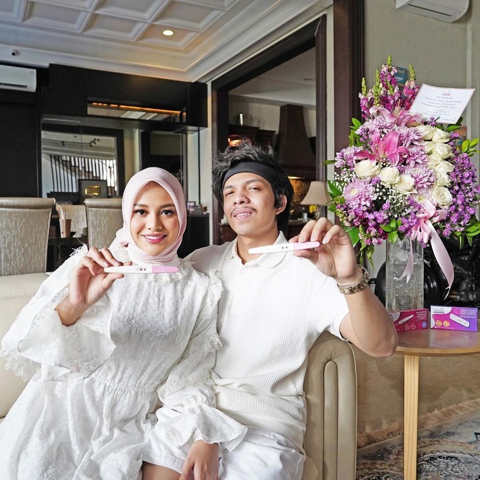 Mengumumkan kabar bahagia bersama sang suami tercinta, Aurel nampak begitu anggun dengan hijab berwarna putih senada dengan bawahan dan pakaian sang suami. (Foto: Instagram/aurelie.hermansyah)