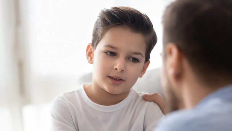 Father and his 7 years old son are talking in the bed.