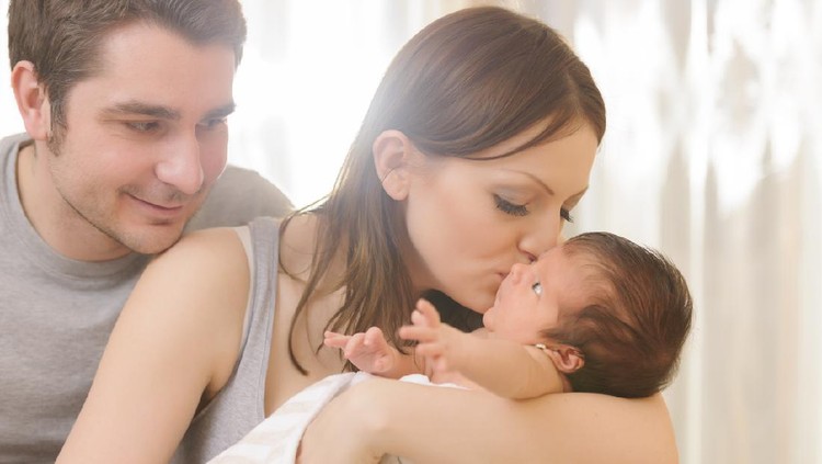 mother kissing his baby girl .