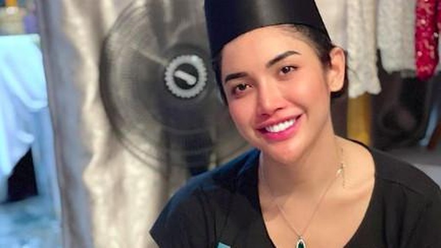 Millen Cyrus pakai peci dan sarung
