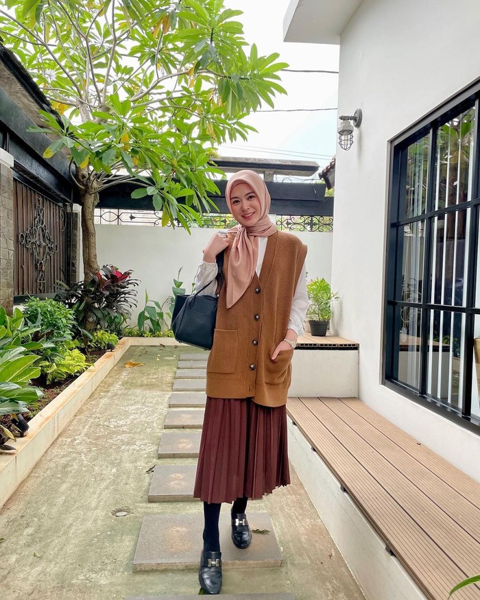 Vest bisa menjadi gaya andalan kamu, Ladies. Padukan saja vest oversized yang mampu menutupi bagian atas rok panjangmu. Selain manis, kamu pasti bakal tampil mempesona ketika momen silaturahmi nanti. (foto: instagram.com/xolovelyayana)