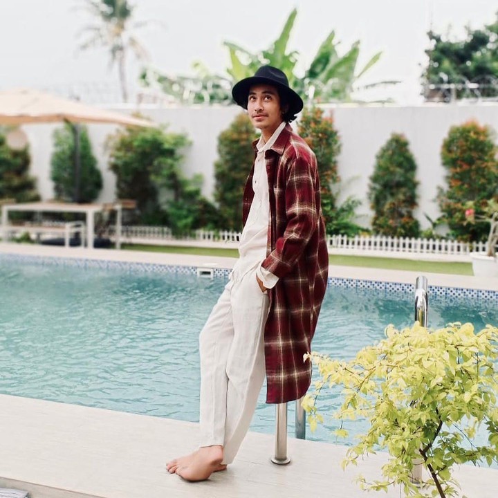 <p>Tak hanya tampan, Abidzar juga punya selera fashion yang sangat modis. Tengok saja gayanya ketika berpose di pinggir kolam memakai long plaid coat. (Foto: Instagram: @abidzar73)</p>