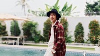 <p>Tak hanya tampan, Abidzar juga punya selera fashion yang sangat modis. Tengok saja gayanya ketika berpose di pinggir kolam memakai long plaid coat. (Foto: Instagram: @abidzar73)</p>