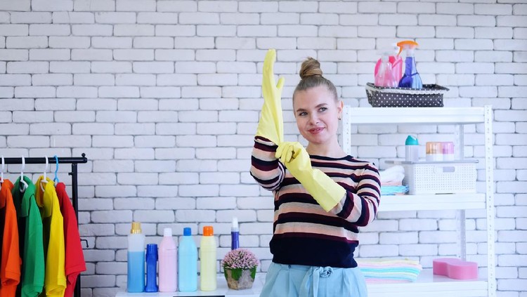Smiling young Caucasian woman Wearing yellow rubber gloves for clean of housework. Housewife lifestyle on holiday concept