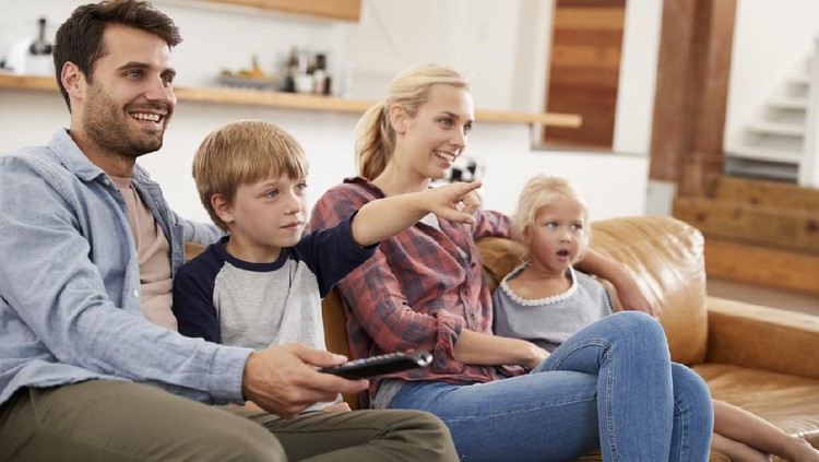 Ilustrasi Nonton Film Family Sitting On Sofa In Open Plan Lounge Watching Television