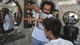 FOTO: Intip Cara Potong Rambut Unik Pakai Pisau Daging Tukang cukur rambut asal Pakistan, Ali Abbas, memangkas rambut pelanggan memakai pisau daging, blow torch, hingga pecahan gelas.