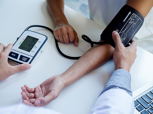 healthcare, hospital and medicine concept - doctor and patient measuring blood pressure.