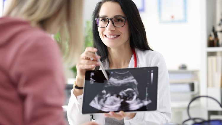 USG Gynecologist showing patient ultrasound of fetus on tablet. Diagnosis and management of pregnancy concept