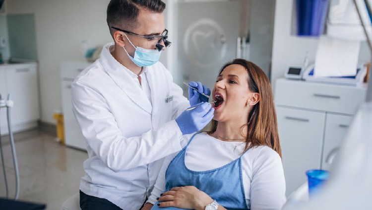 Man and woman, man dentist with a pregnant woman patient in ordination.