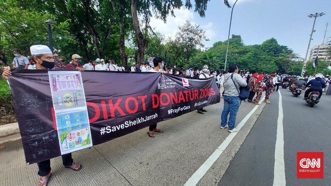 Massa aksi bela Palestina menyalakan suar atau flare di depan kantor Kedubes AS, Jakarta Pusat, Jumat (21/5). Polisi memberikan peringatan.