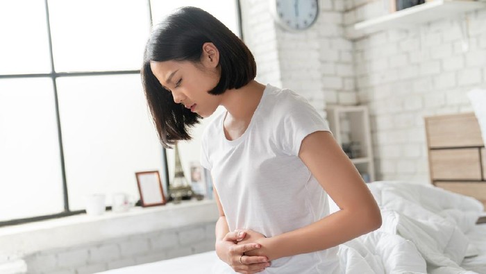 Asian women her stomach aches hard She wakes up in the middle of the night while she sleeps.
