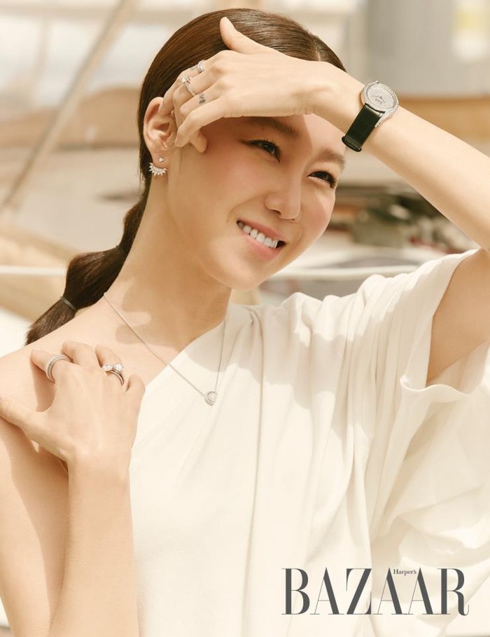 Pemakaian white half shouler blouse dengan perhiasan lengkap di jari-jemari, leher, lengan dan telinganya membuat penampilannya simple tapi tetap glamour/Sumber/Soompi.