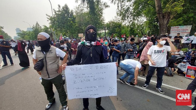 Seorang pemuda berkalung salib terlihat ikut dalam aksi bela Palestina di depan Kedubes AS menyatakan konflik di sana bukanlah sekedar persoalan agama.