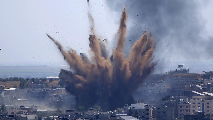 Asap membubung setelah serangan udara Israel di sebuah gedung di Kota Gaza, Kamis, 13 Mei 2021. Warga Palestina yang lelah dengan muram menandai akhir bulan suci Ramadhan, ketika Hamas dan Israel memperdagangkan lebih banyak roket dan serangan udara dan kekerasan Yahudi-Arab berkecamuk di seluruh penjuru. Israel. (AP / Hatem Moussa)