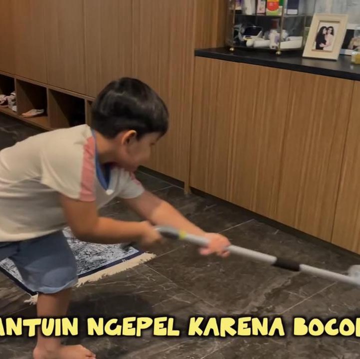 <p>Putra Nisya, Areeq, sampai membantu mengepel lantai yang terkena tetesan air hujan, lho. Rajin banget ya, Bunda. (Foto: YouTube NisNaz Channel)</p>