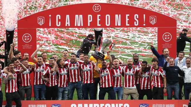 Atletico Madrid mengangkat trofi Liga Spanyol di Stadion Wanda Metropolitano yang kosong setelah menyegel gelar juara La Liga pada Sabtu (22/5) lalu.