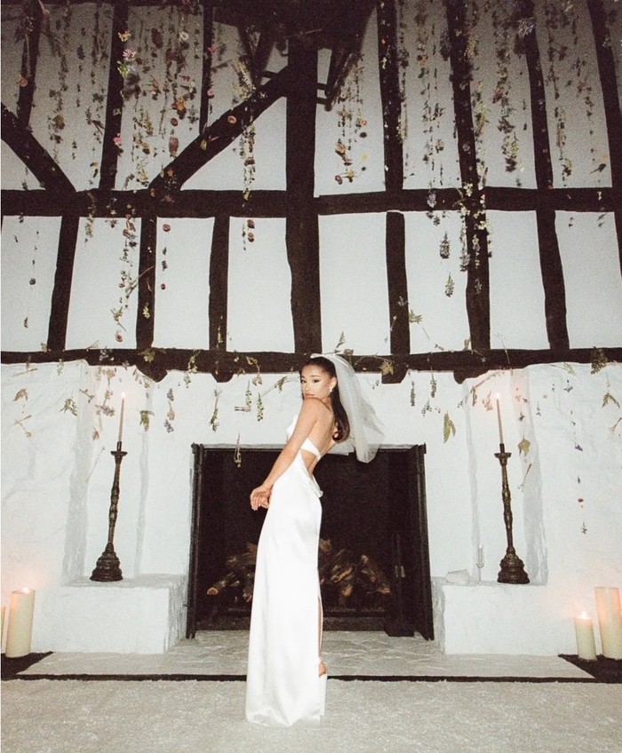 Pada pernikahannya, Ariana tampak cantik dan elegan dalam balutan gaun putih bermaterial satin karya desainer kenamaan Vera Wang. Penampilan Ariana yang simpel ini banyak menuai pujian dari fans dan netizen. (Foto: vogue.com/Stefan Kohli)