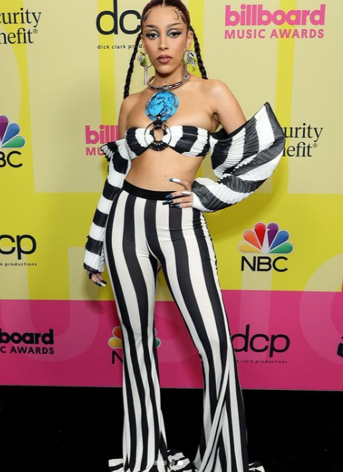 Doja Cat terlihat nyentrik dengan crop top dan celana cut bray yang bermotif garis hitam dan putih. Busana yang ia pakai merupakan produk dari Balmain. Foto: instagram.com/billboard