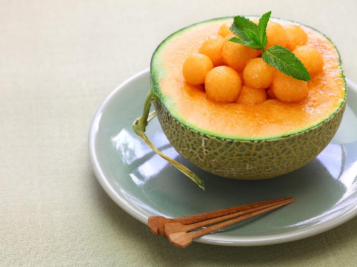 Buah Melon piring penuh potongan melon segar, menampilkan warna oranye cerah yang menggugah selera, simbol dari sumber hidrasi dan nutrisi yang kaya