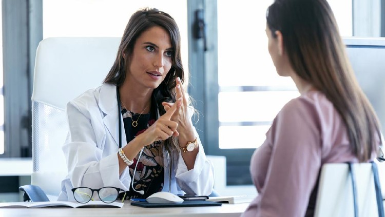 Shot of serious young gynecologist giving guidelines to his pregnant patient in the clinic.
