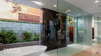 <p>Sementara itu, kamar mandi yang terdapat di rumah mereka terlihat mewah bak tempat spa. Kamar mandi terlihat modern dengan pemilihan warna dingin yang dilengkapi dengan kaca serta bathub berukuran besar. (Foto: YouTube Famous Entertainment)</p>
