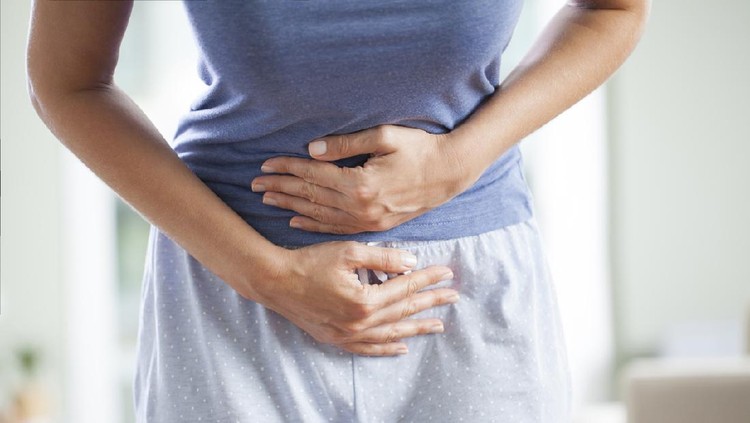 Ilustrasi Kanker Ovarium Young woman having painful stomach ache. Chronic gastritis. Stomach or menstrual cramps. Abdomen bloating concept.