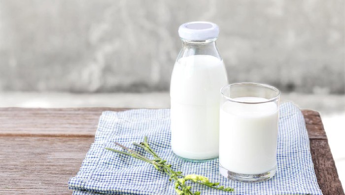 glass of milk and bottle of milk on the wood table. with copy space for text.