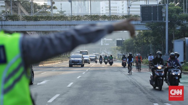 Dirlantas Polda Metro Jaya menegur rombongan road bike yang gowes di luar jalur sepeda saat jam kerja di Jalan Jenderal Sudirman, Jakarta.