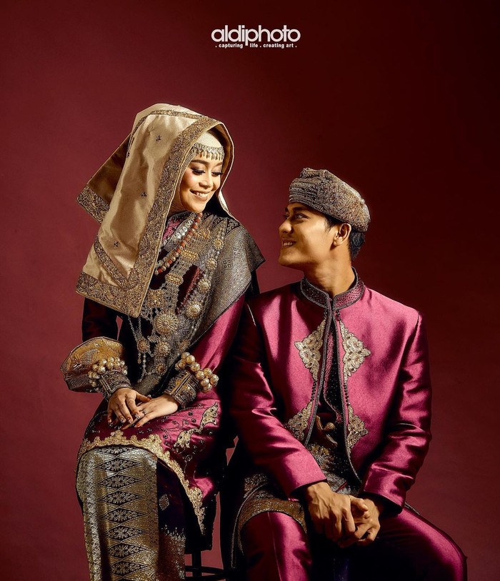 Kedua sejoli yang sering disebut Leslar ini nampak begitu bahagia dengan dalam pose busana Minang bernuansa ungu dan emas. Mereka berpose saling menatap satu sama lain sambil tersenyum bahagia. (Foto: Instagram.com/aldiphoto)