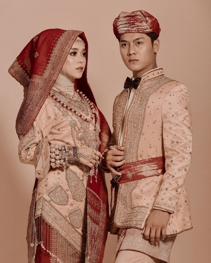 Masih dalam balutan pakaian adat minangkabau, mereka mengenakan pakaian warna serasi dengan perpaduan kain songket merah hati. Tambahan dasi kupu-kupu hitam yang dikenakan Rizky Billar membuatnya semakin terlihat menawan. (Foto: Instagram.com/aldiphoto)