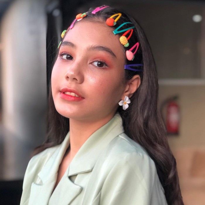 Sosok gadis remaja begitu tergambar dari wajahnya yang terlihat baby face. Dalam salah satu unggahan, ia membagikan potretnya yang terlihat begitu cute dengan rambut tergerai yang dipenuhi penjepit rambut karakter buah. (Instagram.com/ciarachelfx)